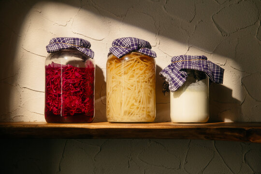 Glass jars with preserved ingredients in warm sunlight

