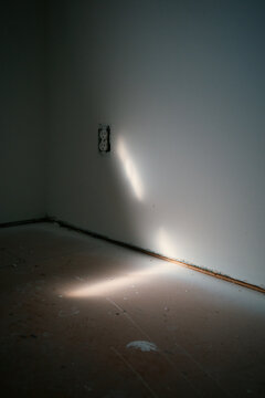 Light reflects off wall in unfinished room in afternoon