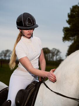 Rider on a White Horse During an Evening Ride in a Field