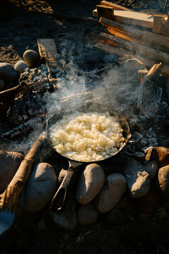 Cooking onions over a campfire on a sunny day by the beach