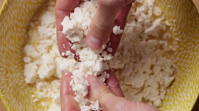Crumbling Feta Cheese Into Bowl Extreme Close Up Top View