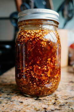 Homemade hot sauce with spices and oil in a glass jar