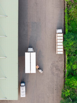 Warehouse loading zone with trucks and moving forklift