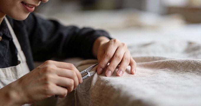 Person sewing fabric with needle and thread close up