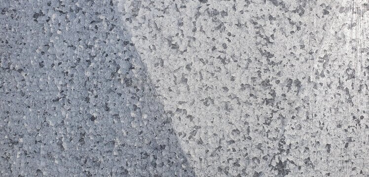 Galvanized steel showing a mottled gray zinc coating with crystalline patterns and rough texture. Ideal for industrial backgrounds, construction materials, or metallic texture designs.