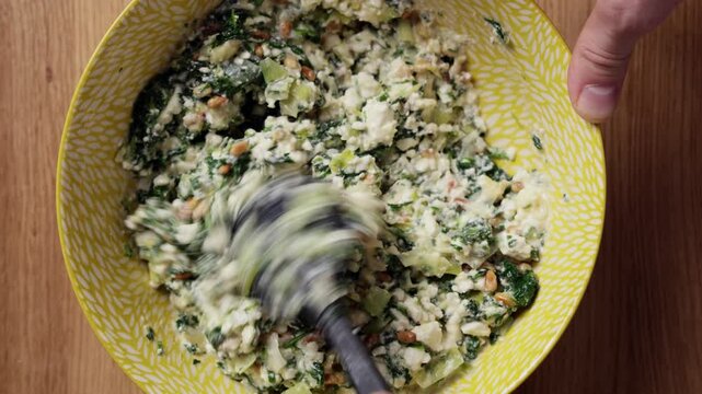 Mixing Greek Spinach Feta Pie Filling In Bowl Top View