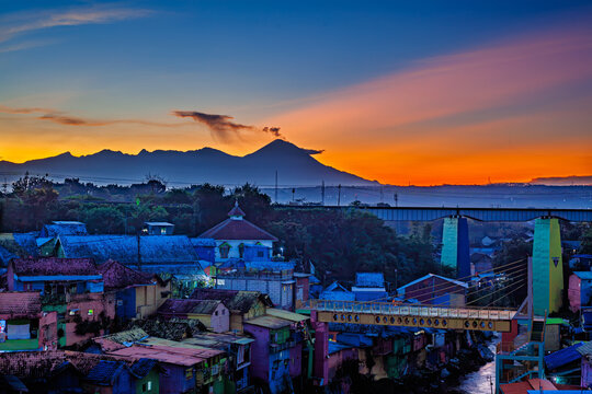 Colorful heritage village Jodipan in Malang with Mount Semeru volcano eruption background during sunrise, famous East Java tourism destination