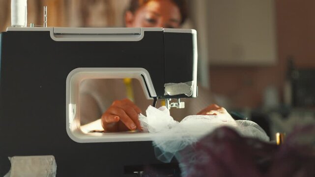 Creating a new dress with a sewing machine in a cozy workshop during the afternoon