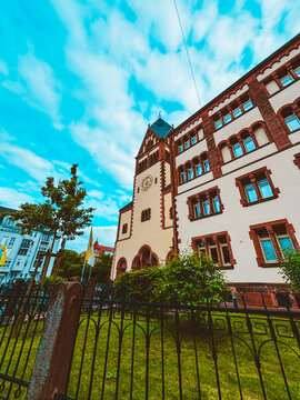 Historic church architecture and modern residential building in urban courtyard under dramatic cloudy blue sky