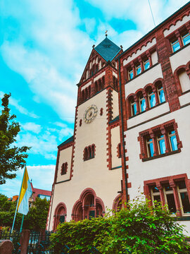Historic church architecture and modern residential building in urban courtyard under dramatic cloudy blue sky