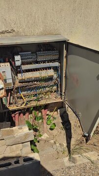 Devastated residential electrical panels caked in mud, debris, and silt after a catastrophic flood