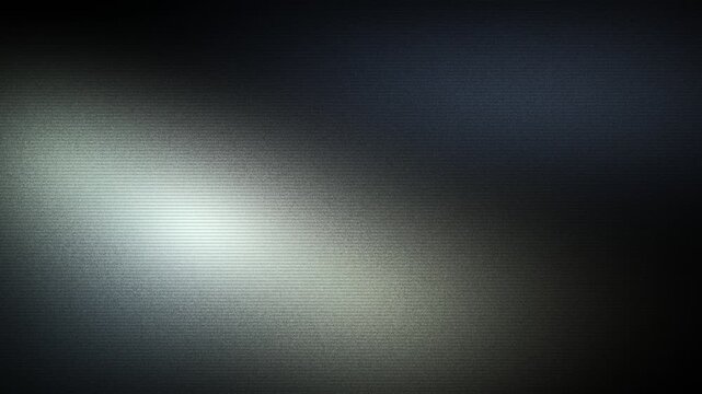Soft white glow drifting across a dark charcoal textured plane