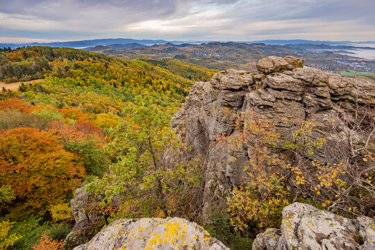 View of Sitno peak in the Stiavnicke vrchy mountains with autumn foliage on the hillsides under a cloudy sky in Ilija, Banska Bystrica Regio, Slovakia.