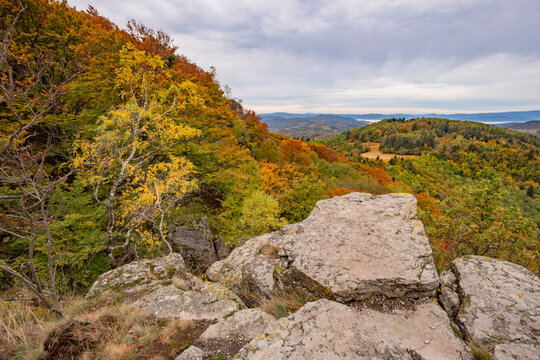 View of the rocky summit of Sitno mountain overlooking a vast autumn forest with vibrant orange and yellow foliage Ilija, Banska Bystrica Regio, Slovakia.