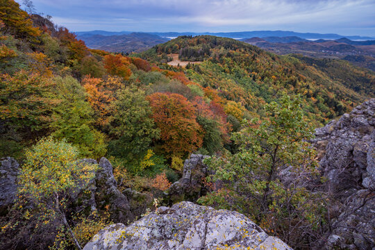 View of Sitno in Stiavnicke vrchy mountains with colorful autumn forest and rocky outcrops under a cloudy sky Ilija, Banska Bystrica Regio, Slovakia.
