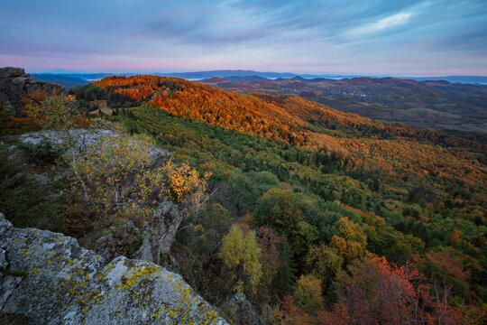 View of Sitno in the Stiavnicke vrchy mountains with autumn forest foliage under a colorful sunset sky in Ilija, Banska Bystrica Region, Slovakia.