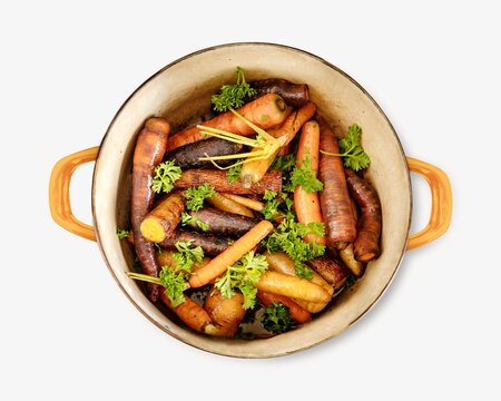A pot filled with roasted carrots and garnished with fresh parsley.