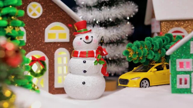 Near the big Christmas tree in Christmas town, in front of the colorful houses, there are snowmen with letters and Santa Claus with a gnome