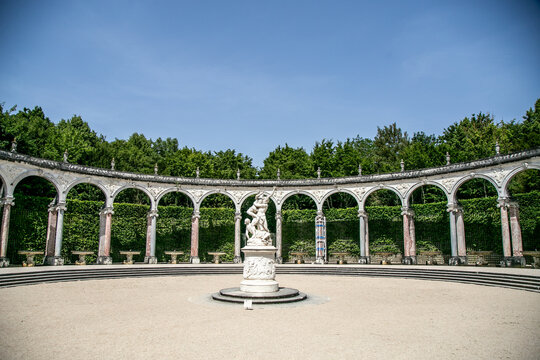 The Colonnade Grove (Bosquet de la Colonnade) in the Gardens of the Palace of Versailles, France, beneath a clear blue sky. Designed by Jules Hardouin-Mansart and constructed from 1685