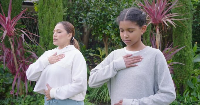 African American mom and teen daughter using breath prompts hands on chest or belly calming in garde