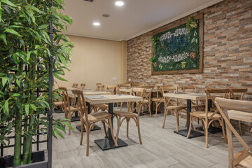 Fototapeta premium A rustic yet elegant dining room dominated by long communal tables of aged pine, combined with banquettes and an exposed brick wall.
