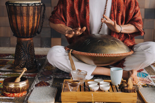 Close-up of a man's hand playing a modern musical instrument - the Orion tongue drum during the tea ceremony
