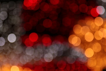 Fototapeta premium Three distinct color zones cool silver left, deep red center and warm orange right divide dark bokeh frame. Black gaps between orbs add depth and drama, ideal for nightlife or premium dark UI overlays