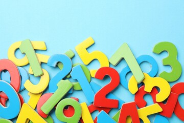 Fototapeta premium Colorful numbers on light blue background, flat lay. Space for text