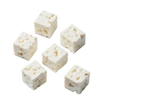 Six irregularly cut, roughly cubed pieces of fresh white feta cheese with crumbly texture, subtle shadows, isolated on a transparent background. Concept for gourmet food product photography