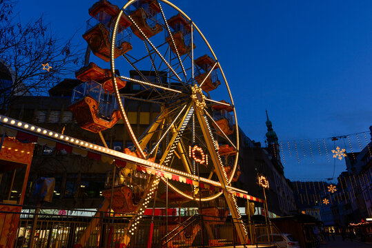 Beleuchtetes Riesenrad auf dem Weihnachtsmarkt in Bregenz vor violettem Abendhimmel am Bodensee