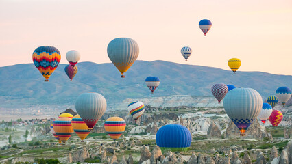 Many colorful hot air balloons over Cappadocia rock valley at sunset © maribom