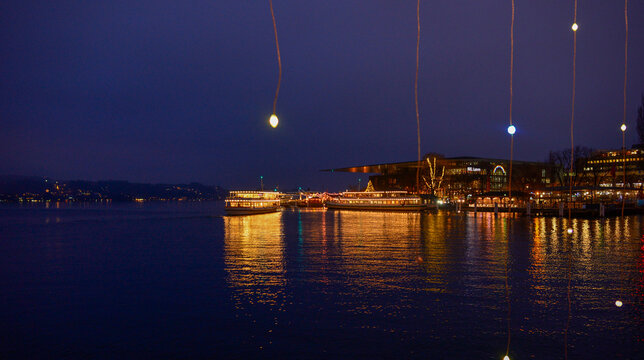 Blick auf den Vierwaldst&auml;ttersee mit beleuchteten Schiffen und dem KKL in Luzern bei Nacht
