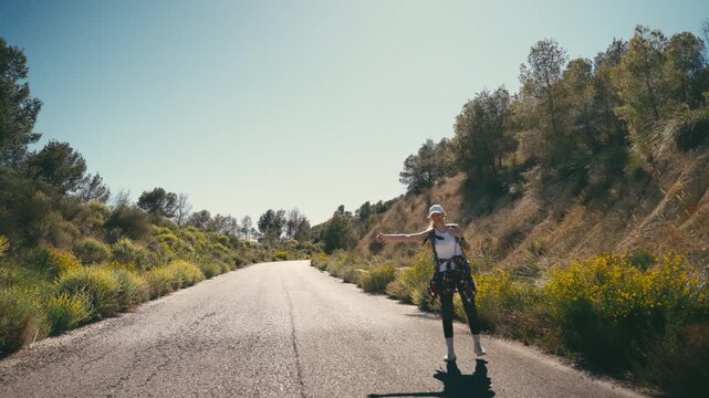 Woman with backpack traveling on an open road toward new opportunities and experiences. New beginnings, life changes, freedom and future possibilities concept