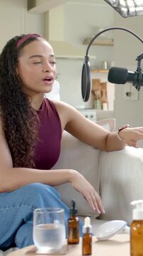 Vertical video: Recording starting, host in maroon top speaking into mic on couch, showing device