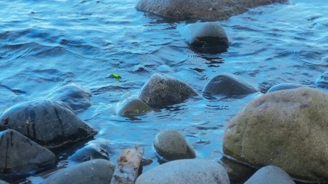 Ocean waves washing over rocks on a peaceful stony beach