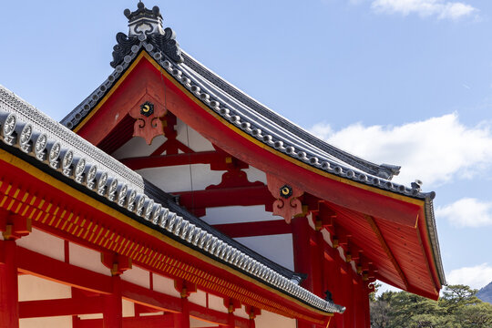 View of traditional Japanese temple architecture with red wooden beams and grey tiled roofs under a blue sky Kyoto, Kyoto, Japan.