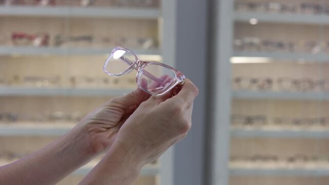 Hands selecting eyeglass frames in a modern optical store
