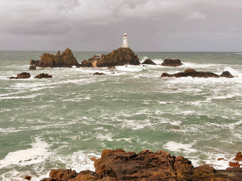 La Corbiere Lighthouse wJersey Channel Islands with rough seas and grey sky