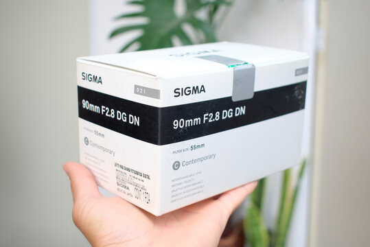 Zapopan Jalisco , Mexico - June 19, 2026: Box for Sigma 90mm F2.8 DG DN Contemporary camera lens with hood held in hand