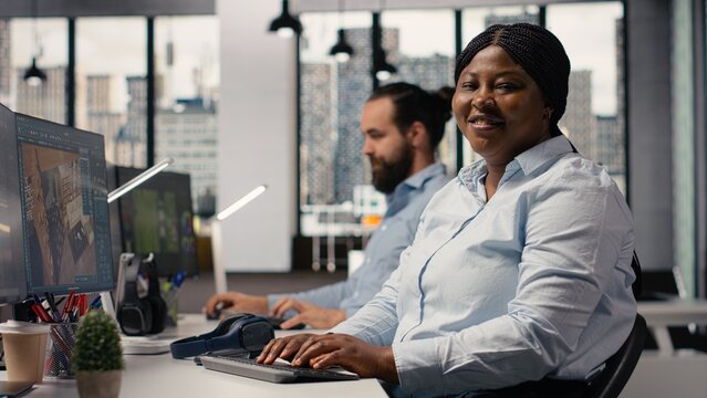 Portrait of black interior designer using high tech software for modern layout, 3D modeling program to design construction floor plan, Architectural blueprints on dual monitors, virtual assets.