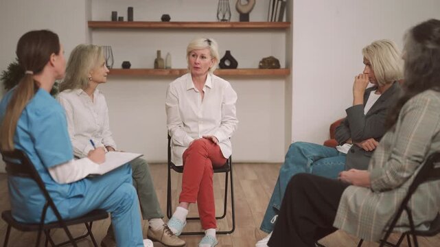 Focus group research on clients behavior or group therapy for senior women. Mature ladies talking and communicating with psychologist or marketing specialist making notes, anti-age and better aging