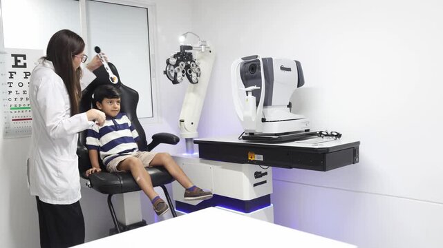 Optometrist preparing pediatric eye examination for young boy in modern eye clinic