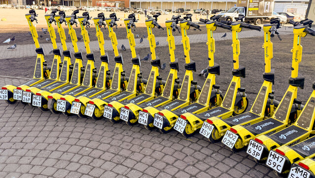 Yellow shared scooters on cobblestone plaza in bright daylight for urban mobility editorial, city transport articles, lifestyle marketing and social media, 5 May 2026 Subitica, Serbia