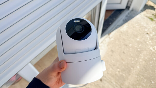 White indoor PTZ security camera held outdoors in soft light suitable for product pages, installation guides, ecommerce and tech blogs, 5 May 2026 Subitica, Serbia