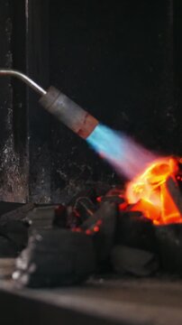 Flame hits charcoal in fireplace while preparing for cooking outdoors