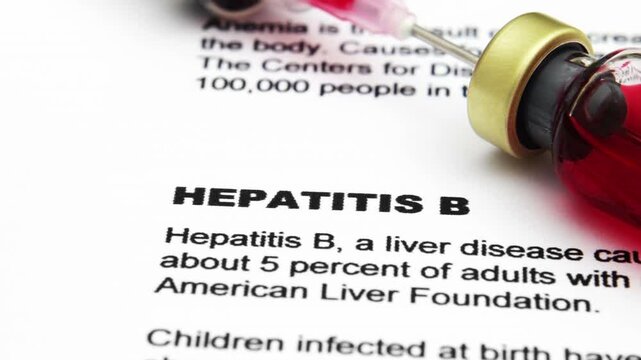 Hepatitis B Vaccine and Syringe on Medical Document Close Up