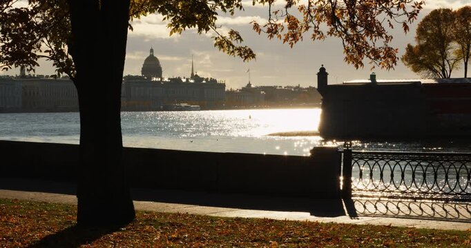 Isaac cathedral, Winter Palace, picturesque metal railings with a double-headed eagle and the crown of the Russian Empire on embankment in St. Petersburg, autumn sunset, incredible sun glare, Russia