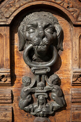 Fototapeta premium Antique bronze door knocker with a lion's head on a colonial door, Quito Cathedral