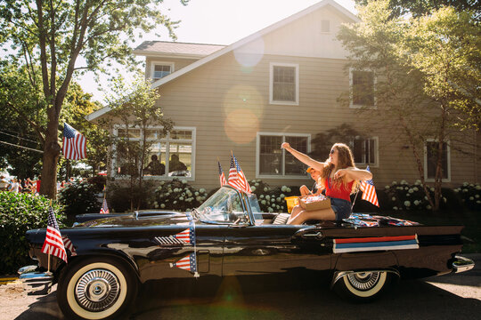 Boy and girl throwing candy in parade, july 4th