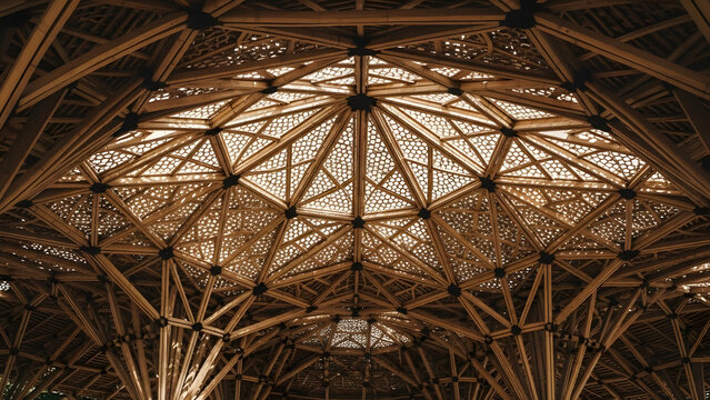 An awe-inspiring view of an intricate bamboo ceiling structure, showcasing sustainable natural architecture with stunning geometric patterns and warm, organic aesthetics under natural light